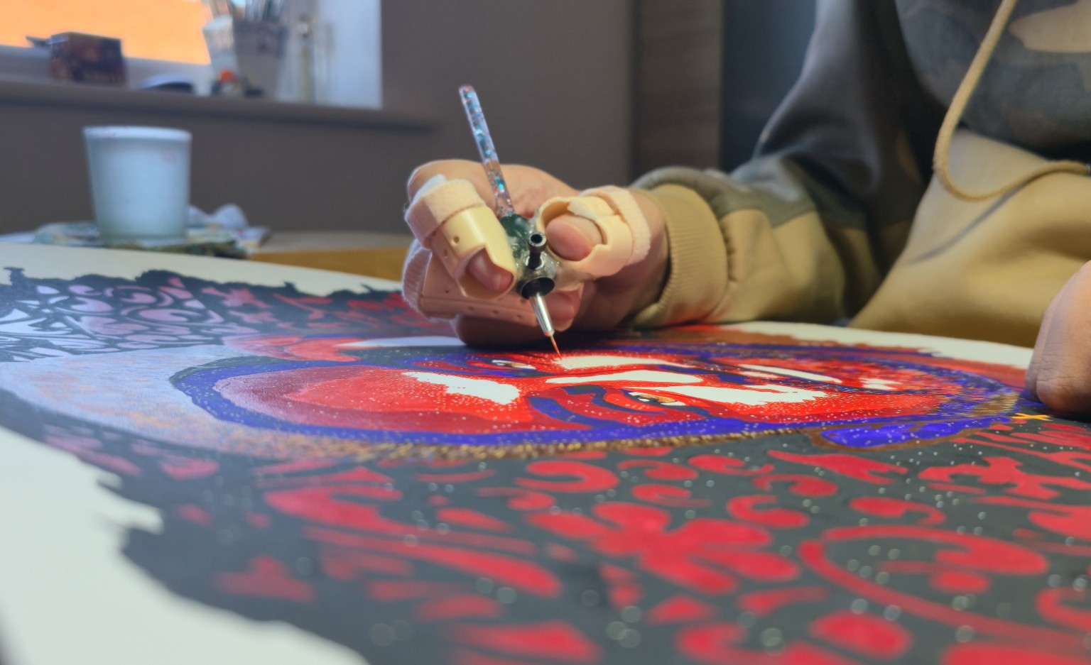 Working on a vivid red and blue painting
